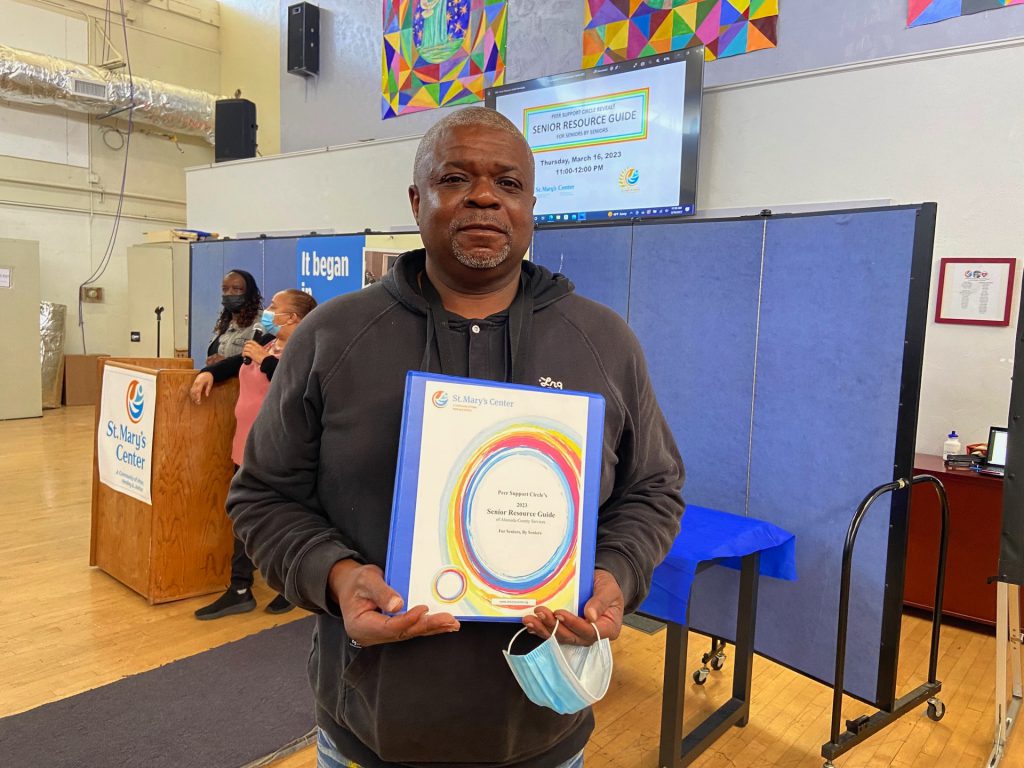 Staff member holding senior resource guide